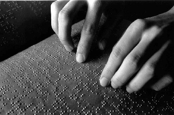 Foto artistica di mani che leggono il codice Braille